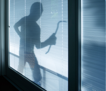 An aggressive and violent man on his way through a partially transparent glass door